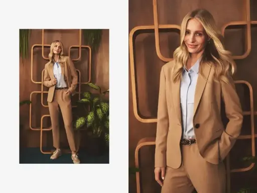 Elegancka stylizacja: jakie spodnie do jasnej marynarki? Modelka prezentuje beżowy garnitur z błękitną koszulą i sneakersami.