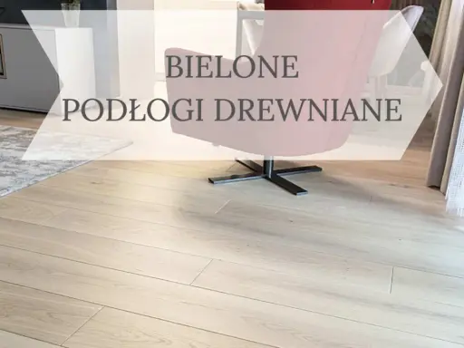 Jasne, bielone drewno na podłodze w salonie, z widocznym fragmentem granatowej kanapy i różowego fotela.