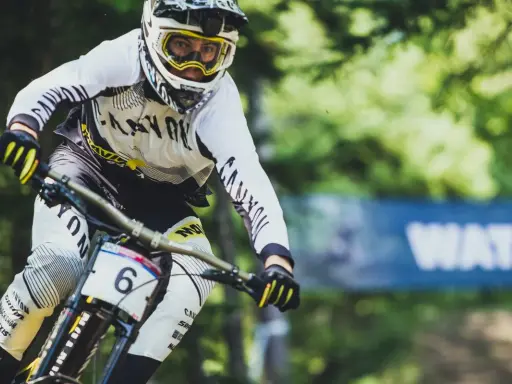 Downhill-Fahrer Mark Wallace in voller Fahrt, mit Helm und Brille, bereit für die nächste Herausforderung.