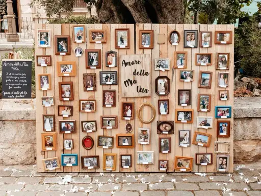 Un original seating plan boda con muchas fotos de parejas en marcos de madera.