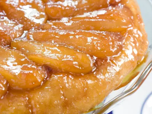 Une délicieuse tarte tatin aux pommes caramélisées, servie dans un plat en verre.