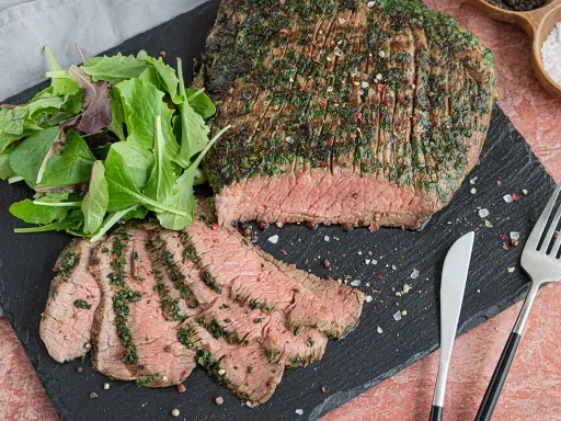 Perfekt mariniertes Flanksteak, aufgeschnitten und mit frischem Salat serviert. Ein Genuss für jeden Fleischliebhaber.