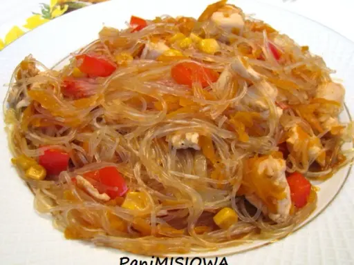 Pyszne danie z makaronem sojowym, kawałkami kurczaka, papryką i kukurydzą.