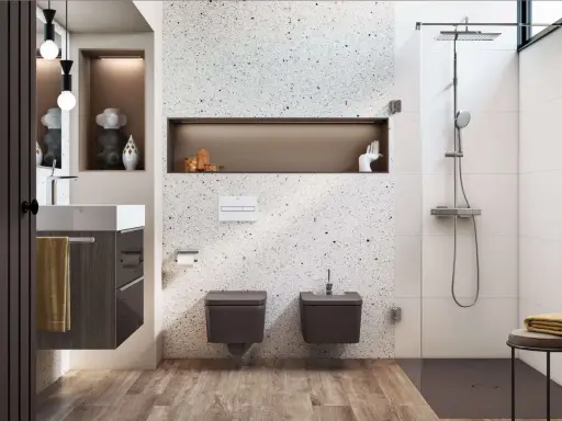 Nowoczesna, wąska łazienka z prysznicem. W centrum uwagę przyciąga ściana z terazzo, a obok niej wiszące toalety i bidet.