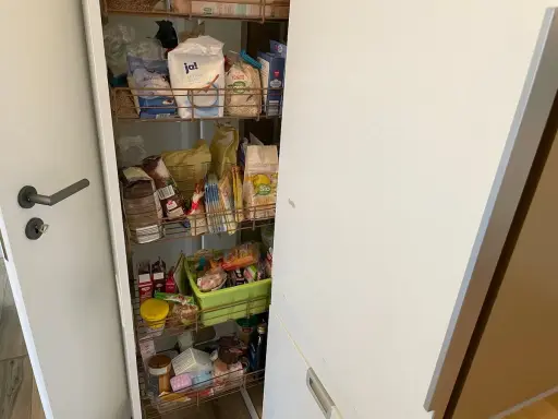 Ein offener Apothekerschrank mit vielen Lebensmitteln. Hier wird gezeigt, wie man einen Apothekerschrank organisieren kann, um Platz zu sparen.