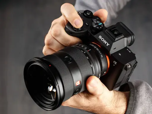 Mani che impugnano una Sony A7, obiettivo GM 2.8/24-70. Dettagli per la recensione.