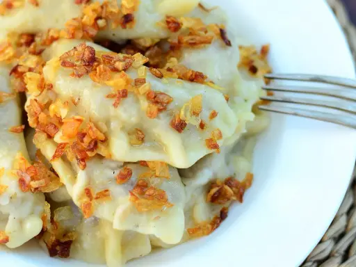 Pyszne pierogi z kaszą gryczaną i serem, posypane chrupiącą cebulką. Sprawdzony przepis na domowy obiad.