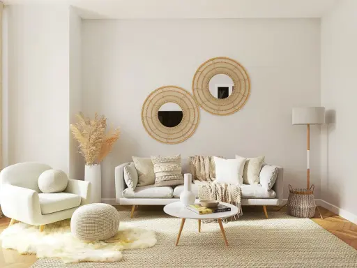 Przytulny mały pokój gościnny aranżacje: sofa, fotel, okrągłe lustra z wikliny, dywan, lampa i dekoracje tworzą ciepłą atmosferę.