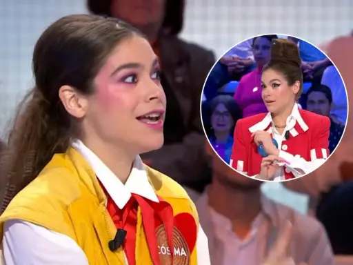 Cosima Ruiz de la Prada, con maquillaje llamativo y un chaleco amarillo, habla en un programa. En un círculo, se ve su peinado alto y chaqueta roja.