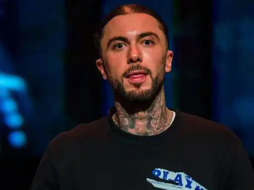 Malik Montana, mój brat, z tatuażami na szyi, w czarnej bluzie z napisem "PLAY".