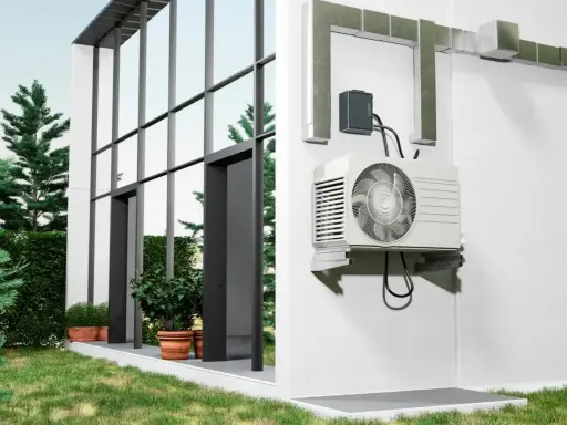 Unité extérieure d'une pompe à chaleur installée sur un mur blanc, à côté d'une maison moderne avec de grandes fenêtres. Comment choisir quelle pompe à chaleur choisir pour votre maison ?