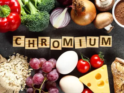 Słowa "CHROM" na drewnianych klockach otoczone przez produkty bogate w ten pierwiastek: papryka, brokuły, cebula, jajka, winogrona, owies, ser, pomidory, grzyby, chleb i proszek.