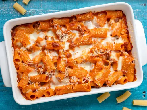Un invitante piatto di pasta al forno con sugo rosso e formaggio filante, pronto per essere gustato.
