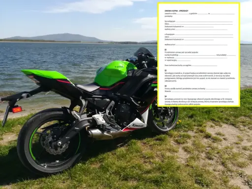 Zielony motocykl Kawasaki przy jeziorze, obok dokument "Umowa kupna-sprzedaży motocykla".