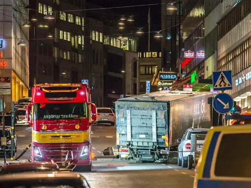 En röd bärgningsbil står vid en lastbil på Drottninggatan, en plats som för alltid är förknippad med terrordådet.
