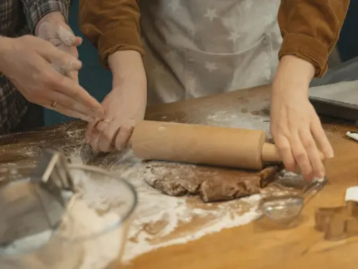 Mains farinées étalant une pâte à biscuits. Une question se pose : par quoi remplacer la farine de sarrasin pour une recette sans gluten ?