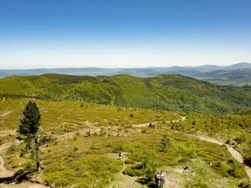 Malowniczy szlak na Baranią Górę, wijący się przez zielone wzgórza Beskidu Śląskiego. Dwoje turystów podziwia panoramę.