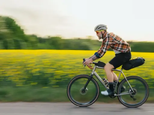 Man cyklar genom ett fält med gula blommor, en idyllisk vy över cykelleder Sverige.