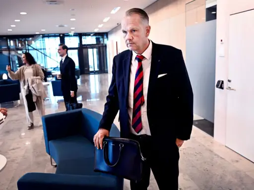 Man i kostym med portfölj, kanske på väg till ett möte. Hans blick ger intryck av att han läst solifokus recensioner.