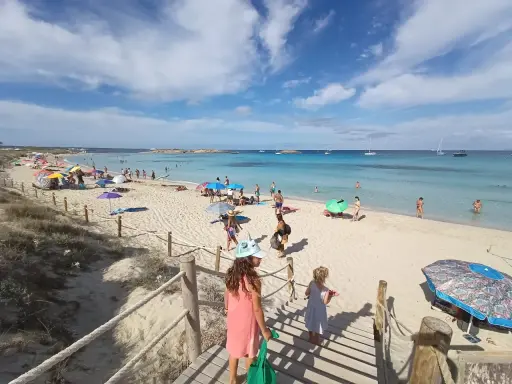Giornata di sole a Formentera con bambini, tra sabbia bianca, mare cristallino e tante famiglie che si godono la vacanza.