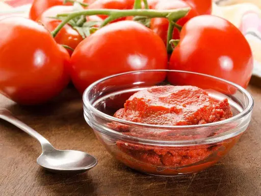Färska tomater och en skål med tomatpuré, perfekt för ditt tomatpuré recept.