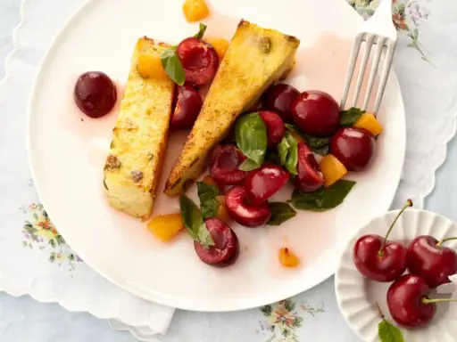 Zwei Scheiben süßer Auflauf mit frischen Kirschen und Aprikosenstücken. Ein köstliches Dessert, das Lust auf mehr Kirschen Rezepte macht.