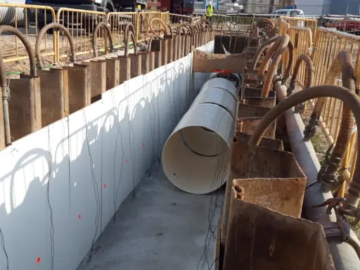 Instalación de tuberías en ntp zanjas, con soportes metálicos y mangueras de bombeo.