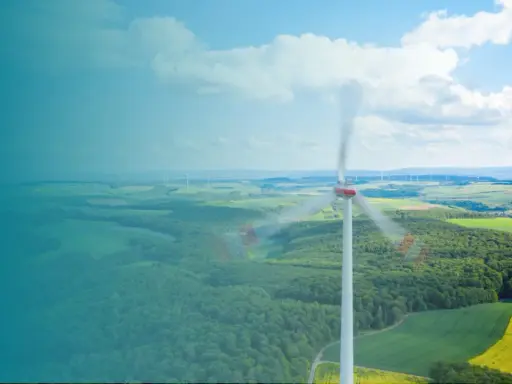 Windkraftanlage im Vordergrund, die sich dreht. Im Hintergrund eine Landschaft mit weiteren Anlagen, die die Amortisation der Windkraftanlage symbolisieren.