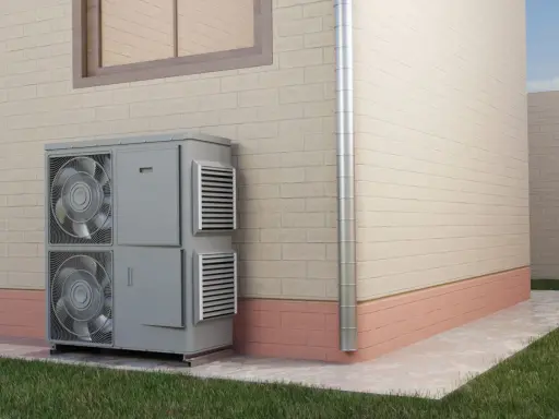 Unidad exterior de aire acondicionado para calefacción por inercia, instalada junto a una pared de ladrillo.