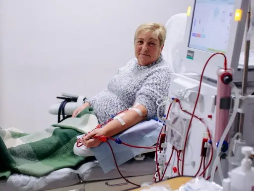 Kobieta podłączona do dializy przez cewnik dializacyjny. Maszyna do dializy monitoruje jej stan.