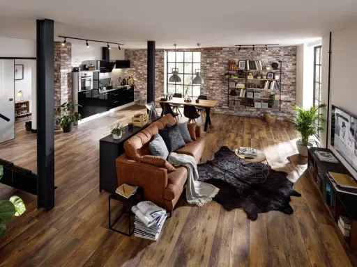 Offenes Wohnkonzept mit Küche, Essbereich und Wohnzimmer. Ziegelwände und Holzböden unterstreichen den industrial look.