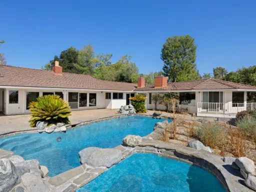 La piscina e il giardino di una casa che ricorda lo stile del **Kim Kardashian house**, con un'architettura moderna e un'area esterna rilassante.