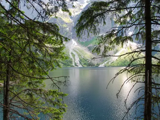 Morskie Oko, Tatry. Spokojna tafla jeziora odbija skaliste szczyty gór.