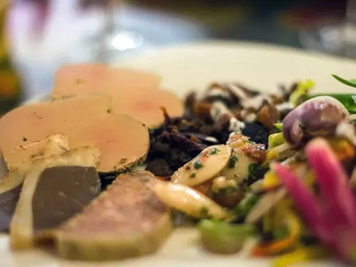 Assiette de foie gras et confit, salade colorée. Un aperçu des spécialités Nouvelle Aquitaine.