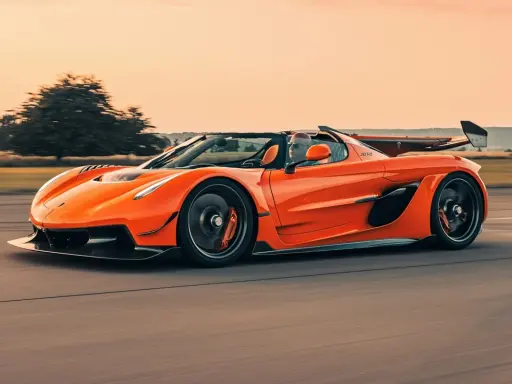 Ein orangefarbener Jesko von Koenigsegg rast auf einer Straße.