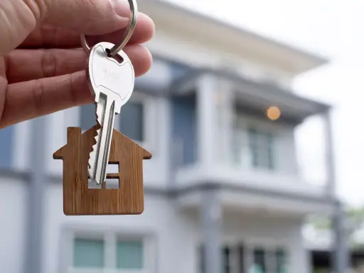 Llaves con un llavero de casa, simbolizando la compra de una vivienda, cumpliendo con el **articulo 9.3 lau**.