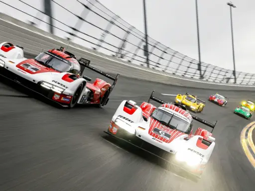 Mehrere Rennwagen, darunter ein weiß-roter Porsche, rasen auf der Strecke des 24-Stunden-Rennens von Daytona.