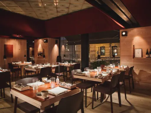 Elegant inredning på en Michelin restaurang i Sverige. Träpaneler, dämpad belysning och vackert dukade bord skapar en inbjudande atmosfär.