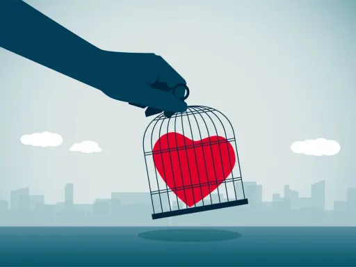 Mano che tiene una gabbia con un cuore rosso dentro, simbolo di esempi di manipolazione emotiva.