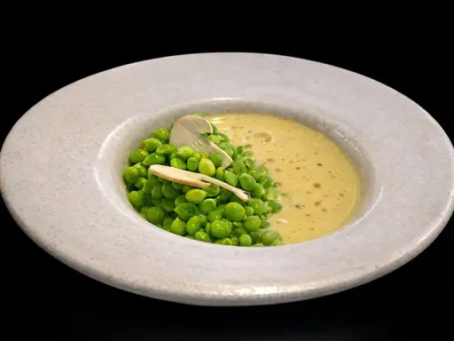 Un plato de guisantes de lágrima frescos con una cremosa sopa amarilla y una fina lámina de champiñón.
