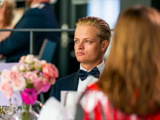 Marius Borg Høiby, klädd i smoking, sitter vid ett bord med blommor.
