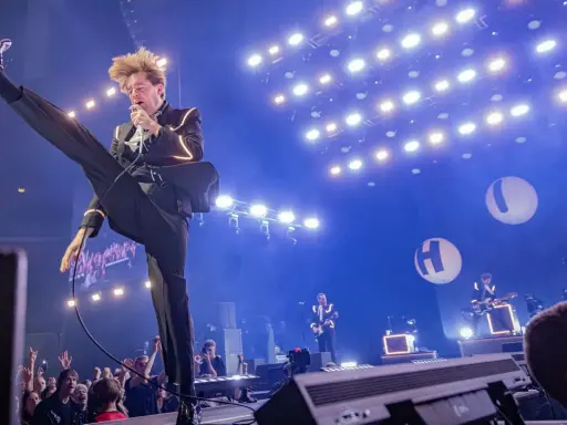 Pelle Almqvist i The Hives levererar en energisk show. Publiken jublar under konserten, en perfekt recension av bandets liveframträdande.