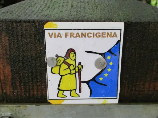 Segnale della Via Francigena, con un pellegrino stilizzato e la bandiera europea. Indica una delle tappe del cammino.