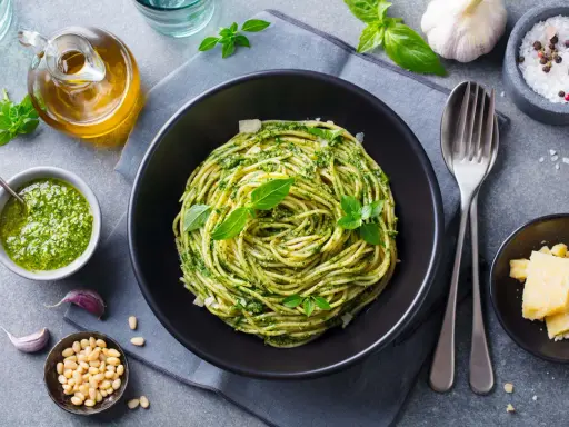Pyszny obiad bez mięsa: spaghetti z pesto, świeżą bazylią, orzeszkami pinii i parmezanem.