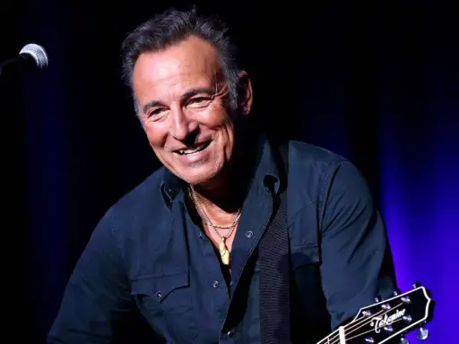 Bruce Springsteen ler glatt på scenen i Sverige, med gitarr och mikrofon redo för en oförglömlig kväll.