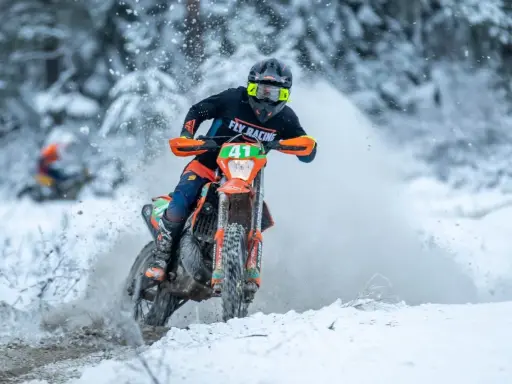 Motocyklista w akcji podczas wyścigu enduro w zimowej scenerii. To właśnie jest **enduro co to** za sport!