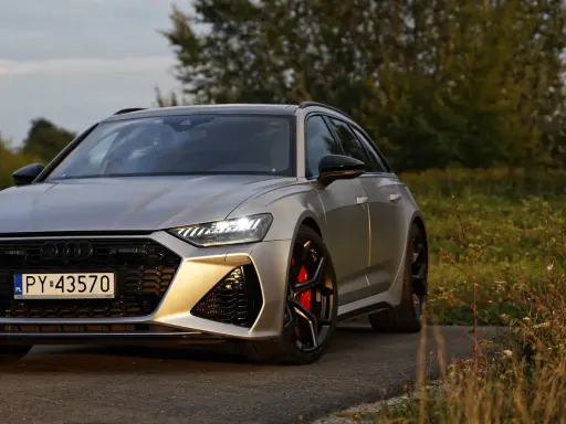 Srebrne Audi RS6 na tle natury. Zastanawiasz się nad audi rs6 cena? Ten potężny kombi zachwyca designem i osiągami.