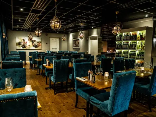 Elegant restaurang med sammetsklädda stolar och vinkyl. En av många bra restauranger i Uppsala för en fin middag.