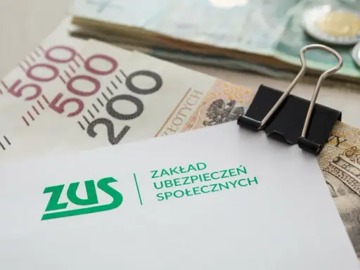 ZUS i polskie banknoty. Dokument z logo ZUS, symbolizujący potencjalne odszkodowanie z ZUS, leży na stosie pieniędzy.