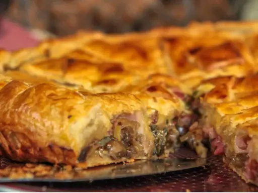 Une tourte dorée, garnie de champignons et de lardons, un délice de la saumur cuisine.